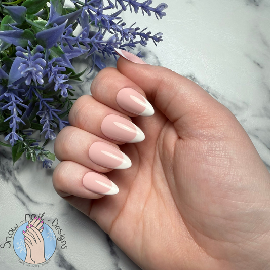 French Manicure handgemaakte press-ons. Roze basis met witte tips, gedragen aan de hand met lavendeltak op marmeren achtergrond
