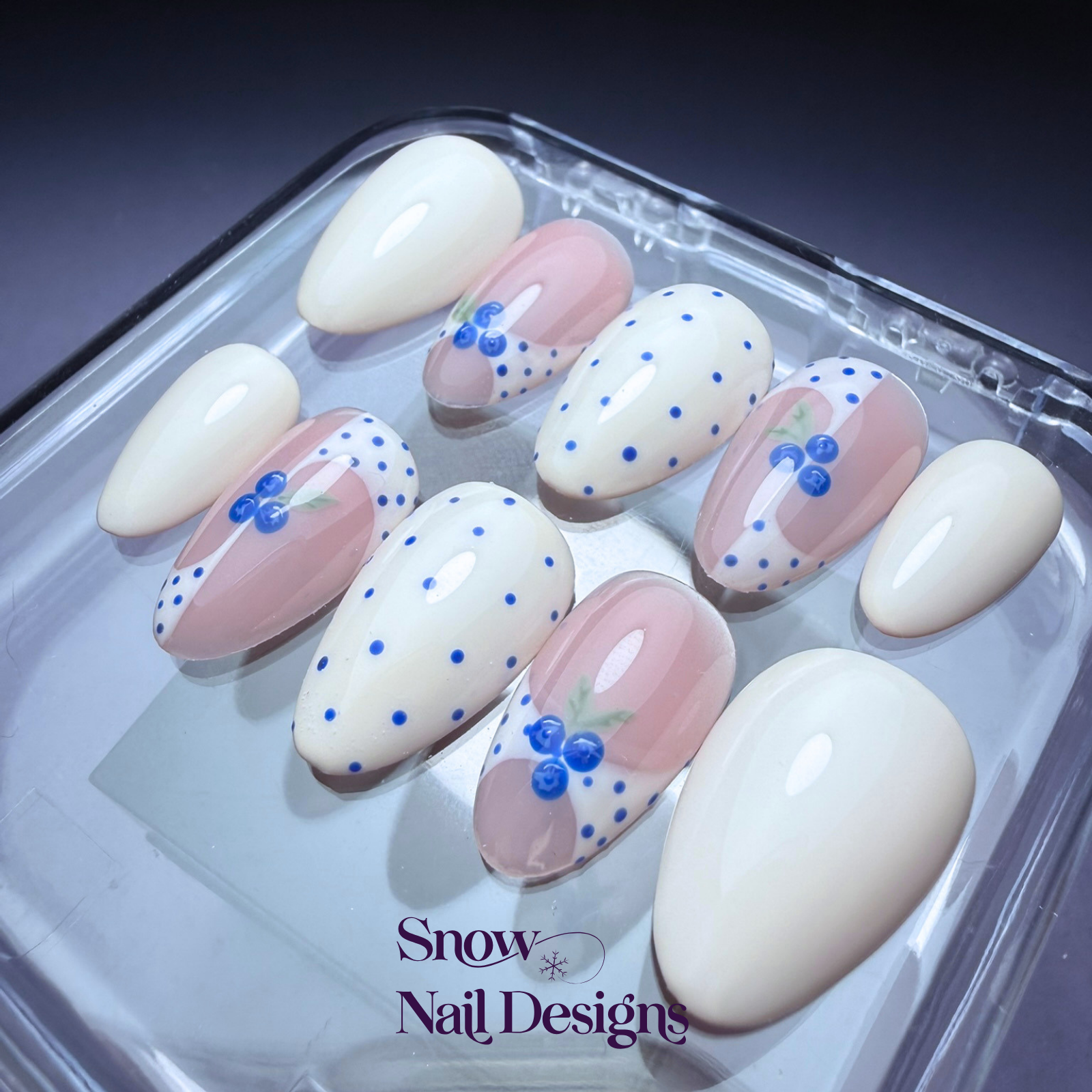 Flatlay van crème press-on nagels met blauwe stippen en blauwe bessen – Blueberry Milkshake van Snow Nail Designs