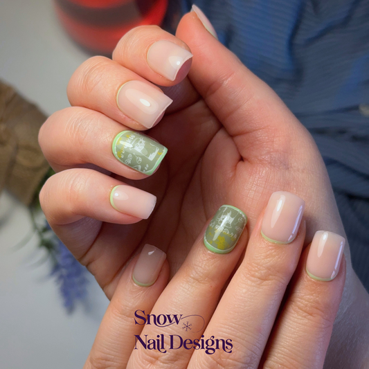Nude press-on nagels gedragen aan de hand met limoengroene reverse French en een accent nagel met citrus details en een drankje – Fresh Lime van Snow Nail Designs