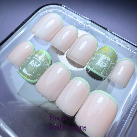 Flatlay van nude press-on nagels gedragen met limoengroene reverse French en een accent nagel met citrus details en een drankje – Fresh Lime van Snow Nail Designs