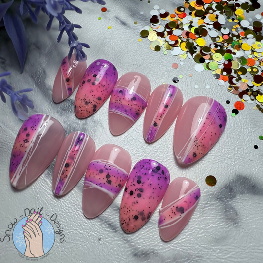 Milkshake Glaze press-ons in zachte roze en paarse tinten met speelse confettieffecten.
