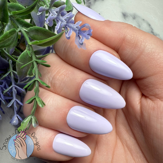 Hand met lichtpaarse press-on nagels in een zachte, elegante stijl.